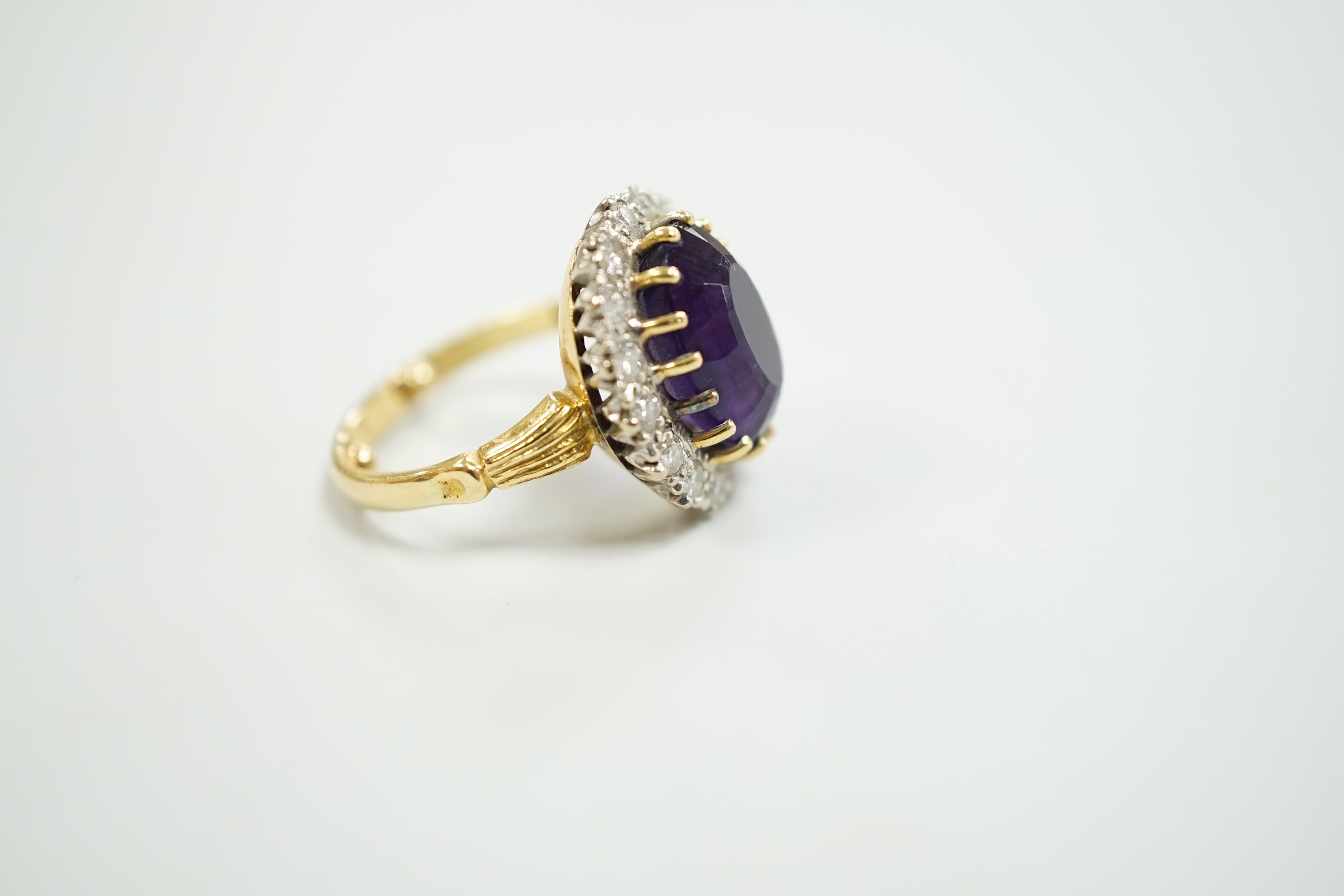 A yellow metal, amethyst and diamond set oval cluster dress ring, size K, gross weight 7.5 grams.